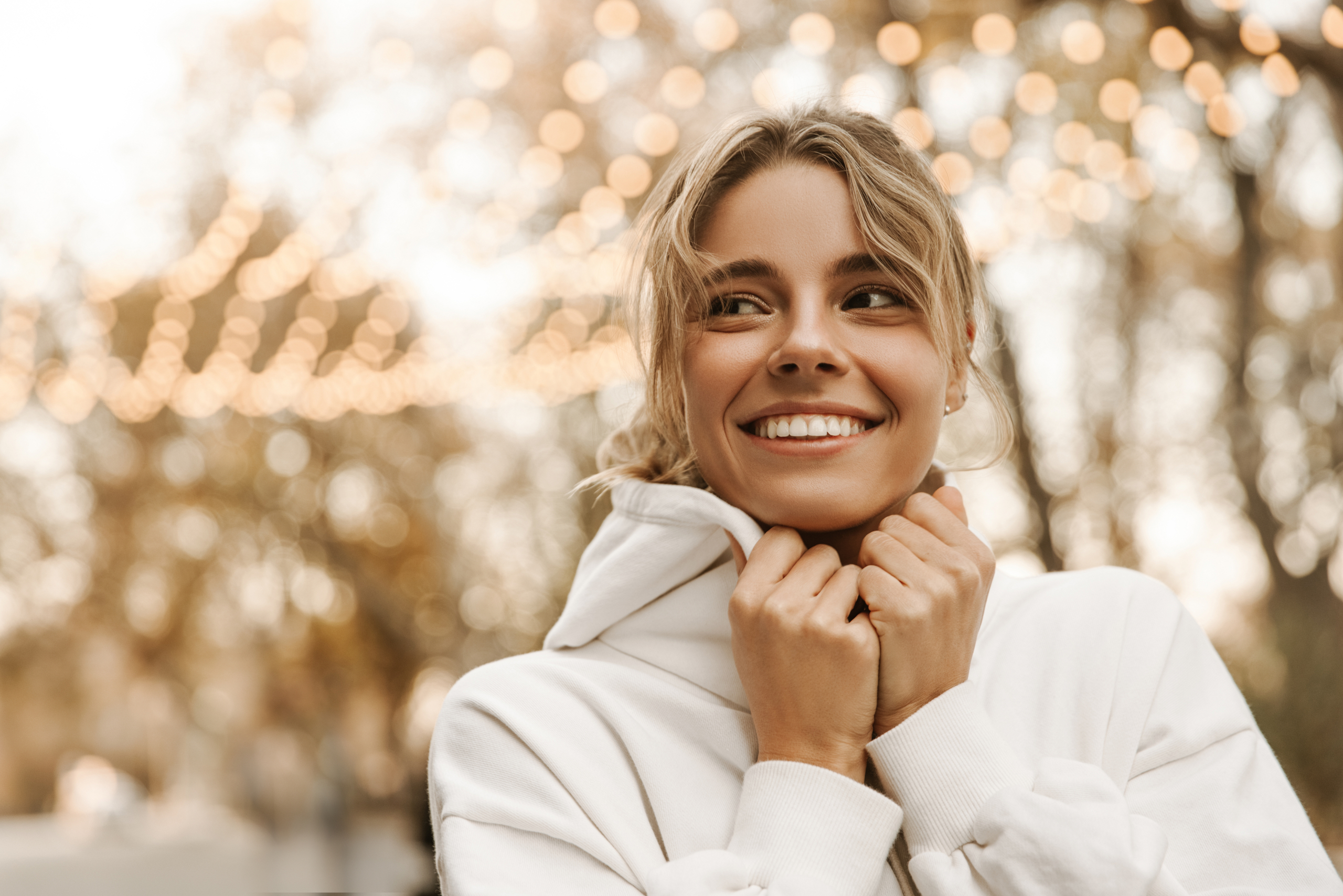 Smiling woman enjoying an outdoor moment with bright, natural-looking teeth, symbolizing the confidence and durability provided by dental crown treatments in Cupertino - Dental Crown Cupertino
