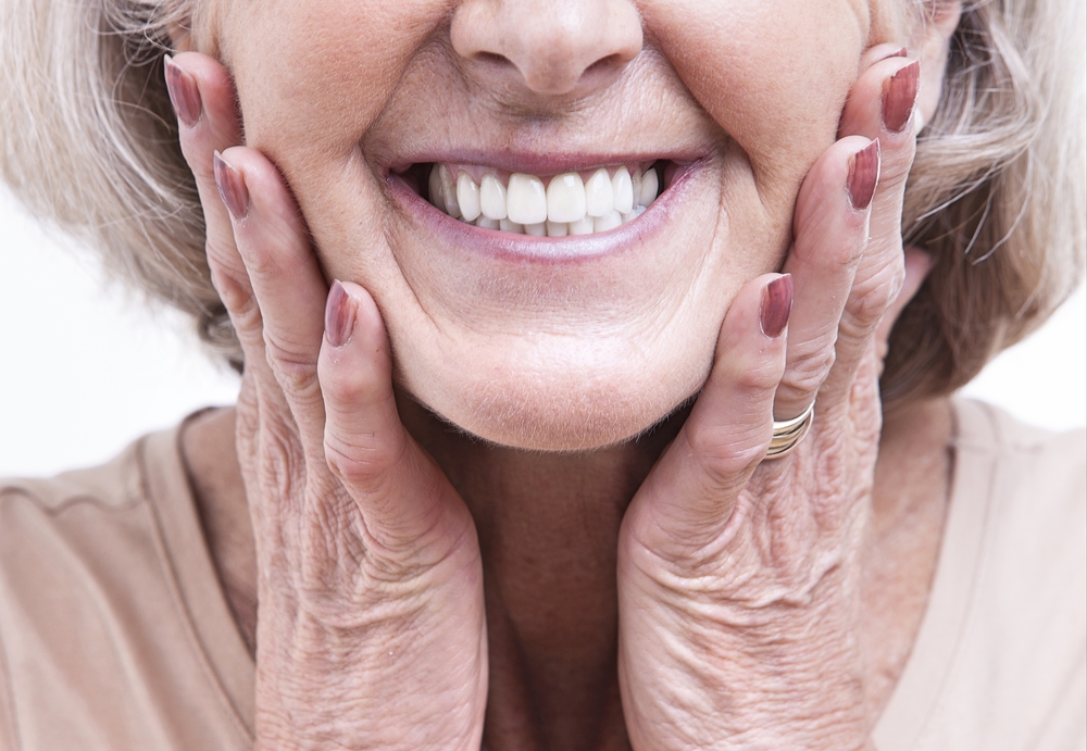 Senior Woman Showing Restored Beautiful Smile - Dental Implants Cupertino Close-up portrait of a senior woman smiling with full, natural-looking teeth, representing the long-lasting tooth replacement benefits of dental implants in Cupertino - Dental Implants Cupertino