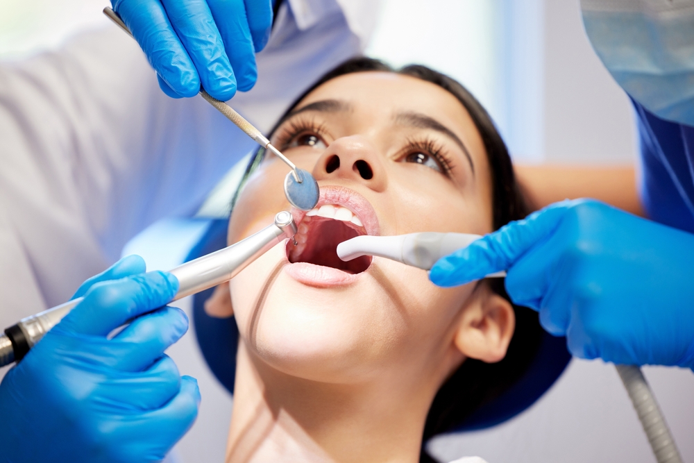 Close-up of a patient undergoing a dental procedure with professional instruments and protective equipment, highlighting precise care provided during oral surgery treatments in Cupertino - Cupertino Oral Surgery
